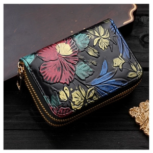 Détail du porte-cartes vintage noir avec motif floral gaufré et fermeture éclair dorée chic
