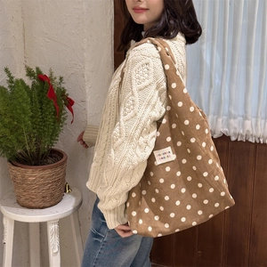 Close-up of brown corduroy tote bag with white polka dots and zakka label details