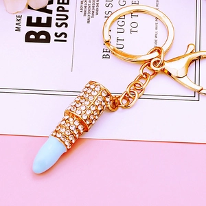 Close-up of a sparkling rhinestone-encrusted lipstick keychain with gold metal plating