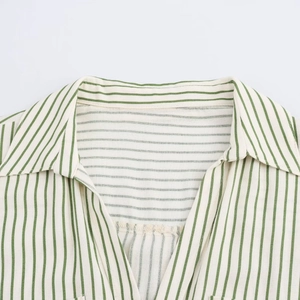 Détail de la chemise à rayures vertes et blanches montrant le col et la texture