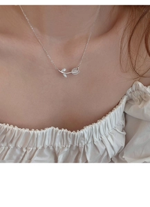 Detail of s925 silver tulip necklace featuring white chalcedony worn by a model