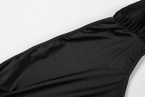 Close-up of black dress fabric with detailed ruched pleats and flat seam stitching