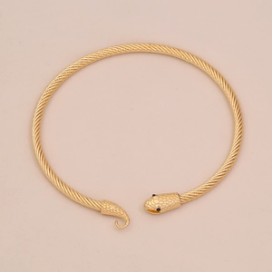 Dettaglio ravvicinato del bracciale dorato a forma di serpente con trama a spirale e testa