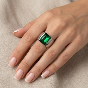 Minimalist titanium steel ring with a large emerald cut green gemstone on model hand