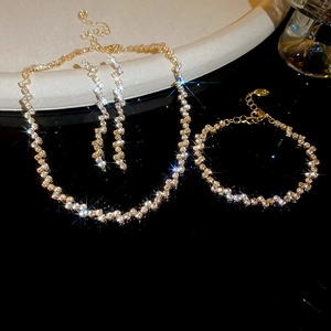 Macro view of gold fringe jewelry set with sparkling zircon stones on a white stand