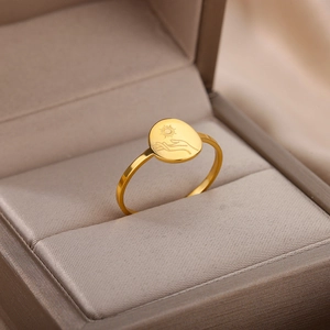 Detail shot of 18K gold plated celestial ring with sun engraving in a beige jewelry box