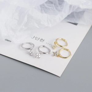Detail of silver and gold plated clover earrings with sparkling cubic zirconia stones