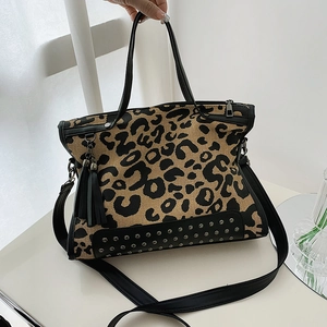Fashionable leopard print canvas tote bag with black leather trim and fringe detail