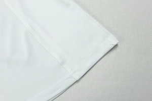 Detail view of white fabric texture and precision stitching on elegant V-neck dress