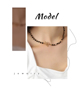 Detail of black agate bead necklace with a gold OT toggle clasp on model neck