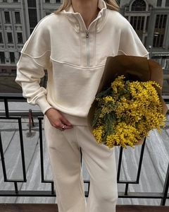 Detail of cream sweatshirt set featuring a half-zip collar and delicate embroidery