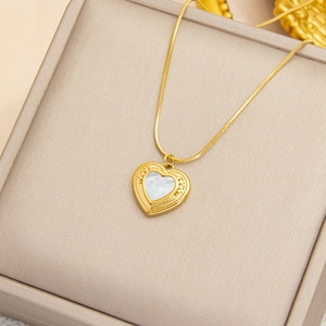 Collier cœur doré avec incrustation de nacre blanche sur une boîte à bijoux élégante