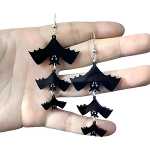 Fashionable black acrylic bat earrings for Halloween dangling from a silver metal hook