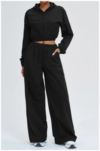 Detail of black sports set with cropped zip hoodie and high-waisted wide-leg pants