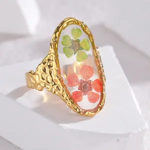 Minimalist gold titanium steel ring with pressed flowers and hammered texture on white stone