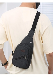 Close-up of black canvas chest bag with adjustable strap and sport logo detail