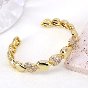 Dettaglio del bracciale a cuore dorato con pavé di zirconi e finitura lucida