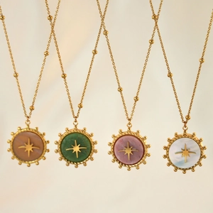 Detail of eight-pointed star pendants with natural stones in multiple colors on gold chains