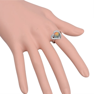 Macro shot of silver heart ring with color-changing gemstone on a model's hand