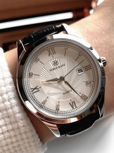 Close-up of minimalist leather watch with rhinestone indices and calendar display window