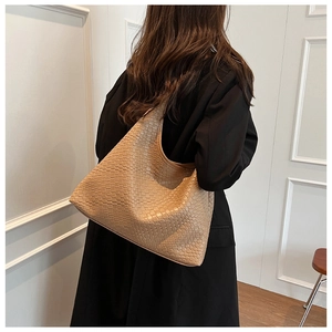 Detail of camel woven hobo tote bag featuring intricate checkered leather texture