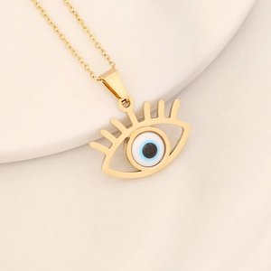 Detail of gold evil eye pendant with blue enamel and eyelashes on a delicate chain