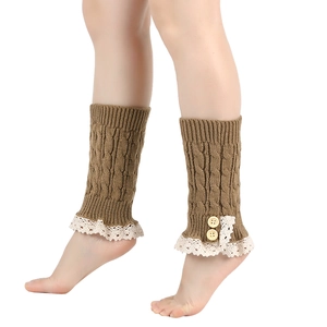 Detailed close-up of brown knit leg warmers with white lace trim and wooden buttons