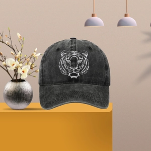 Close-up of white tiger head embroidery on a dark grey washed cotton baseball cap
