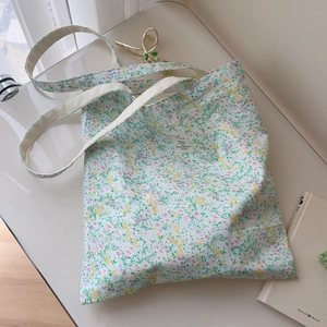 Detail of floral canvas tote bag with yellow and purple flowers and cotton straps