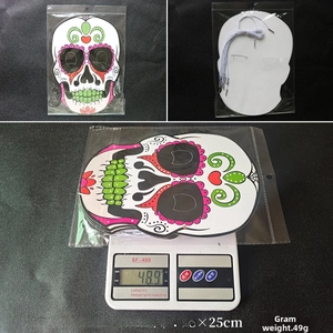 Detail of Day of the Dead paper mask showing colorful sugar skull print and elastic band