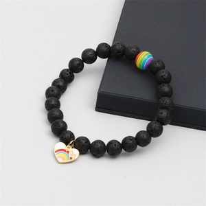 Close-up of black lava stone beaded bracelet with rainbow charm and heart pendant