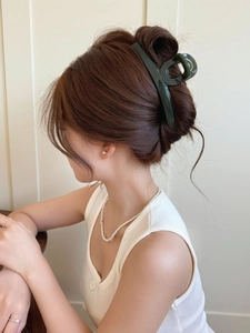 Large dark green butterfly hair claw clip shown in a side view on a brunette woman