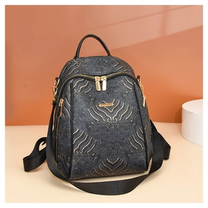 Close-up of black leather backpack with traditional golden water-cloud embossed patterns