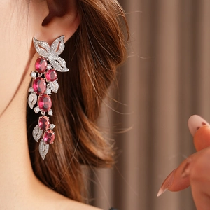 Gros plan détaillé de boucles d'oreilles pendantes argentées avec gemmes rouges