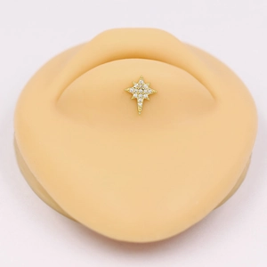 Macro shot of gold star piercing jewelry with clear cubic zirconia on silicone model