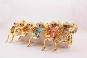 Detailed view of snake-shaped metal keychains with colorful rhinestones in multiple finishes