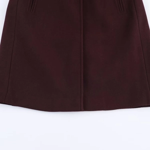 Close-up of the wine red wool coat hem featuring thick texture and detailed stitching