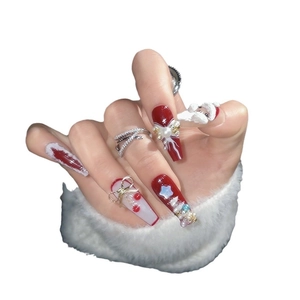 Handmade Christmas press-on nails featuring 3D bows, pearls, and Santa Claus patterns