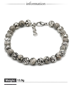 Detail of beaded bracelet featuring grey stone beads, silver spacers, and lobster clasp