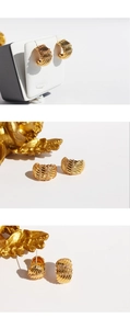 Detailed macro view of gold-plated chunky hoop earrings with wave texture and zircon