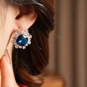 Detail of vintage square navy blue crystal earring with baguette zircon halo on ear