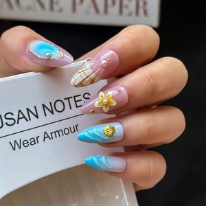 Detailed view of long almond ocean theme press-on nails with 3D pearls and shell charms