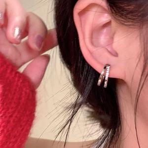 Minimalist double layer silver zircon hoop earrings shown on a female model's ear