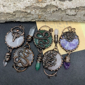 Macro detail of vintage bronze pendants featuring mystical animals and crystal quartz