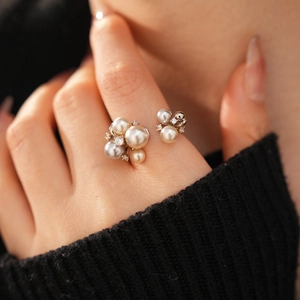 Close-up of elegant pearl cluster ring with zircon stones on silver adjustable band