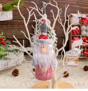 Detail of Christmas gnome ornament with pink knit body and wooden buttons on tree