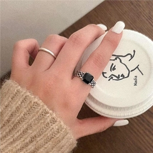 Close-up of vintage 925 silver ring with black stone and braided texture on finger