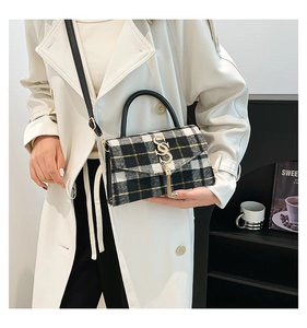 Detail of checkered crossbody bag featuring metal logo, fringe tassel and premium tweed texture