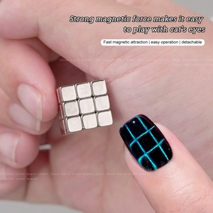 Macro shot of a 27-piece magnetic cube creating grid patterns on blue cat eye nail art