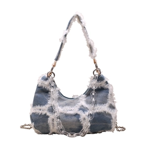 Fashionable denim chain shoulder bag with white fringe and acrylic strap on white background